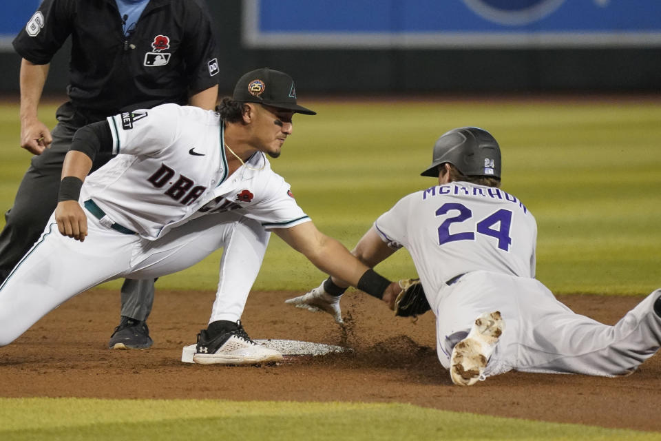 Arizona Diamondbacks' Josh Rojas tags out Colorado Rockies' Ryan McMahon (24) at second base during the second inning of a baseball game, Monday, May 29, 2023, in Phoenix. (AP Photo/Darryl Webb)