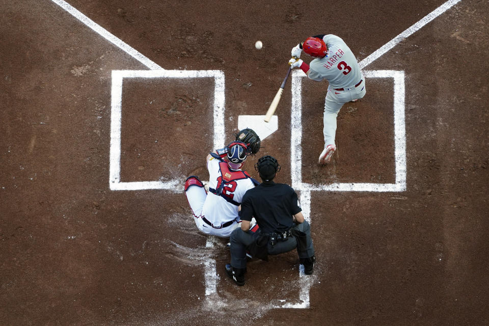 Philadelphia Phillies designated hitter Bryce Harper (3) connects for a single as Atlanta Braves catcher Sean Murphy (12) looks on in the first inning of a baseball game Thursday, May 25, 2023, in Atlanta. (AP Photo/John Bazemore)