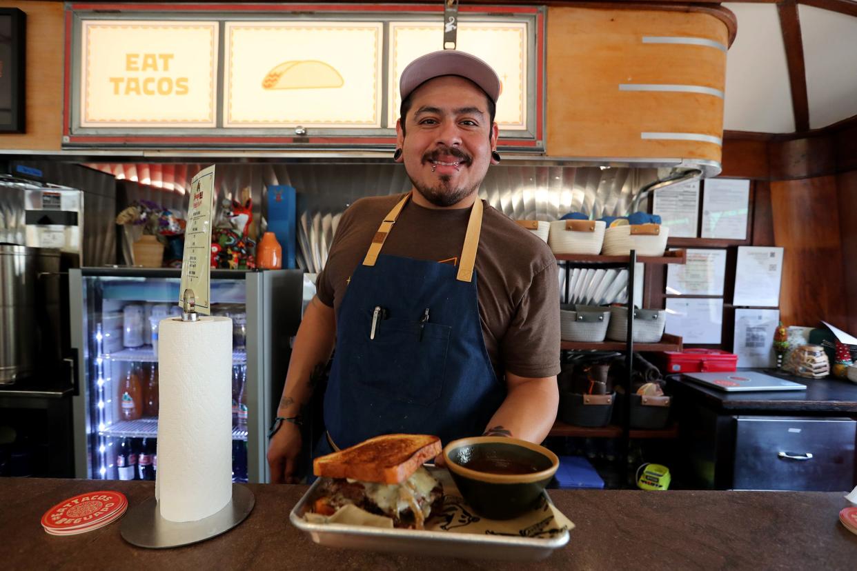 Chef Danial Aranza serves a Birria Burger at Strange Bird, located in the Streamliner on Barnard Street.