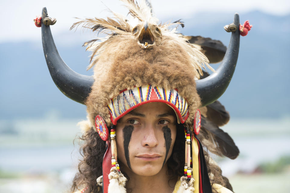 Ota Bluehorse, a member of the Spirit Lake Tribe, wears a headdress adorned with bison horns during a naming ceremony for a white buffalo calf at the Buffalo Field Campaign headquarters in West Yellowstone, Mont., Wednesday, June 26, 2024. The reported birth of a white buffalo calf in Yellowstone National Park fulfills a Lakota prophecy that portends better times. (AP Photo/Sam Wilson)