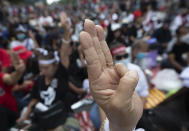 Pro-democracy demonstrators raise a three-finger salute, a symbol of resistance, during a protest outside the Parliament in Bangkok, Thailand, Thursday, Sept. 24, 2020. Lawmakers in Thailand are expected to vote Thursday on six proposed amendments to the constitution, as protesters supporting pro-democratic charter reforms gathered outside the parliament building. (AP Photo/Sakchai Lalit)