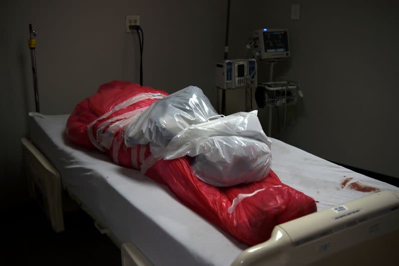 FILE PHOTO: A man who died from the coronavirus disease (COVID-19) is seen wrapped in a body bag in Houston