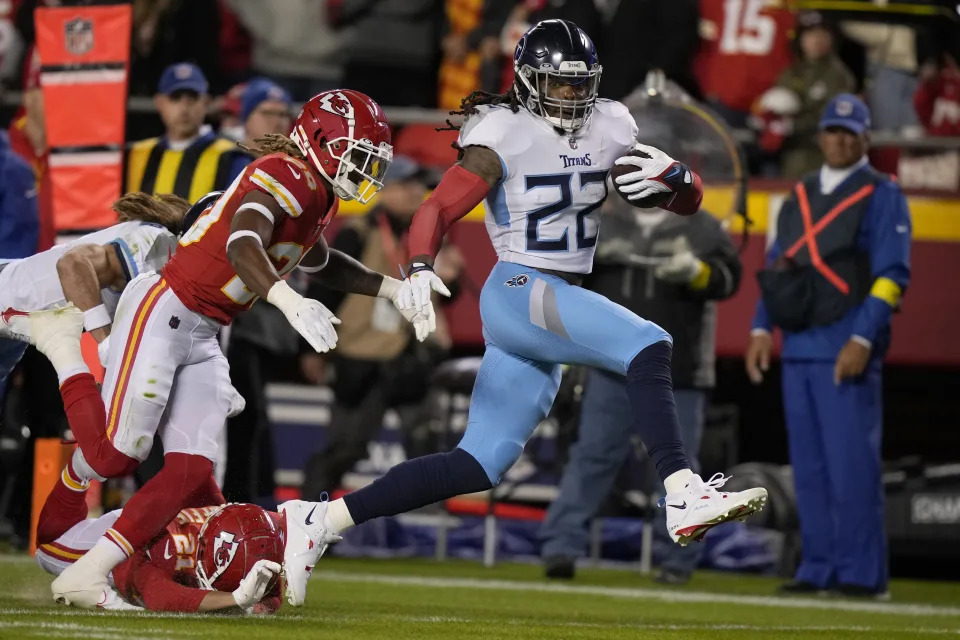 Tennessee Titans running back Derrick Henry (22) runs with the ball past Kansas City Chiefs safety Justin Reid (20) and cornerback Trent McDuffie (21) during the first half of an NFL football game Sunday, Nov. 6, 2022, in Kansas City, Mo. (AP Photo/Charlie Riedel)