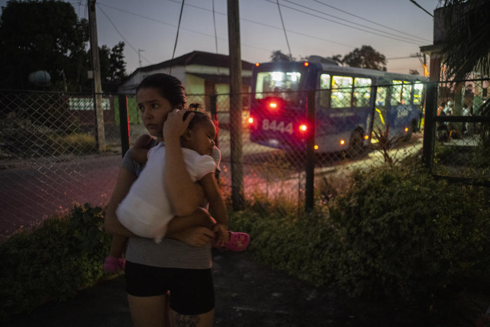 Melanie Rolo Gonzalez holds her daughter Madisson in their home's garden, in Havana, Cuba, Tuesday, Dec. 6, 2022. Days later, they left to migrate to the U.S., along with Melanie’s sister. (AP Photo/Ramon Espinosa)