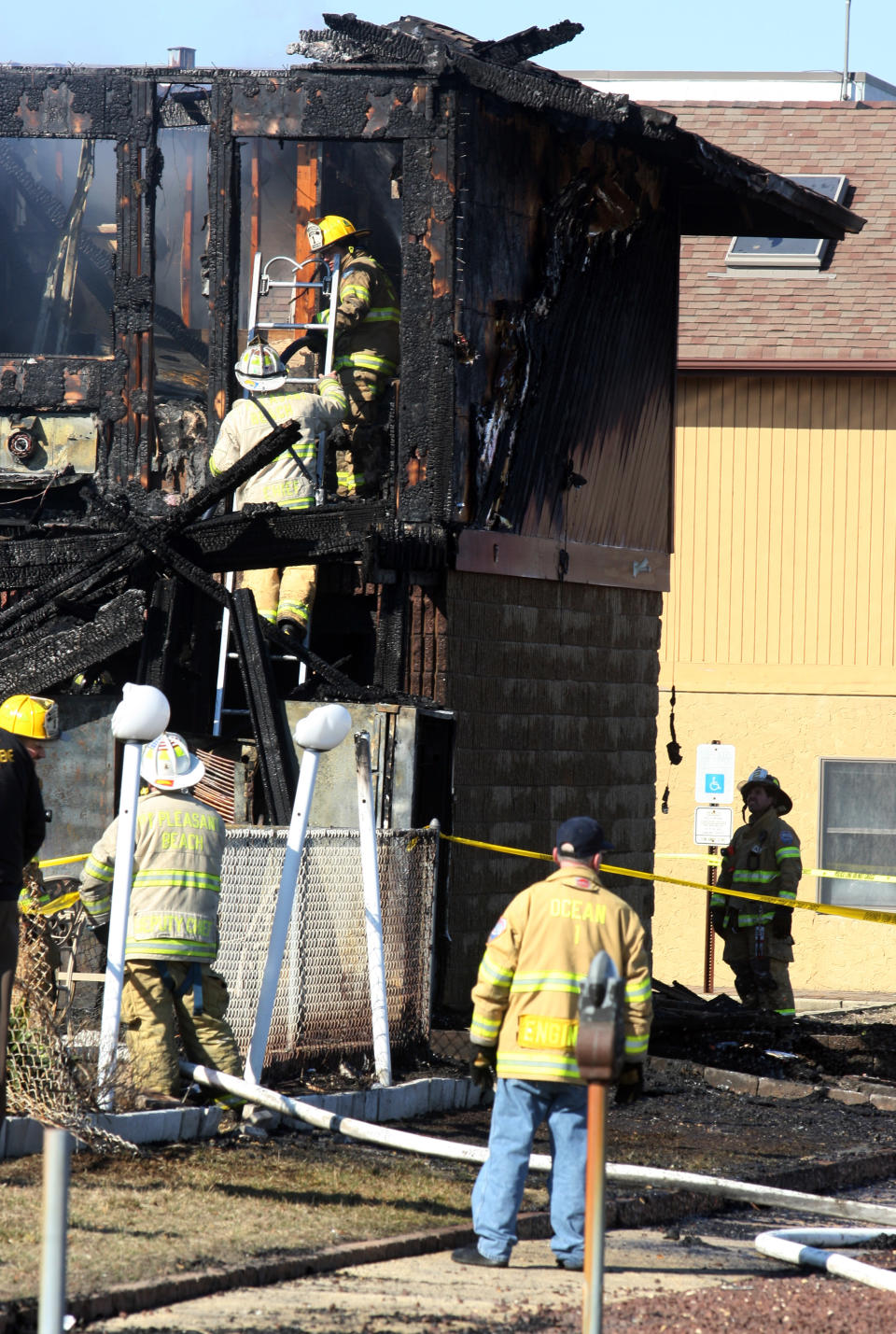 Firefighters investigate an early morning fire at the Mariner's Cove Hotel in Point Pleasant Beach, N.J. on Friday, March 21, 2014. (AP Photo/David Gard)
