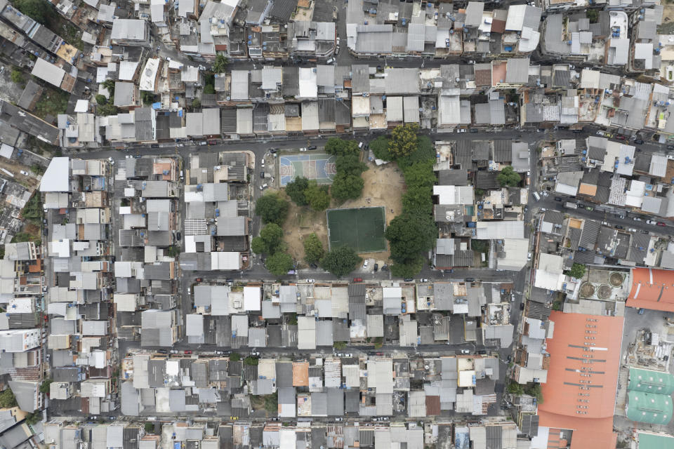 An overhead view of the pitch where young women take part in a soccer training session run by the Bola de Ouro social program at the Complexo da Alemao favela in Rio de Janeiro, Brazil, Thursday, May 16, 2024. (AP Photo/Silvia Izquierdo)