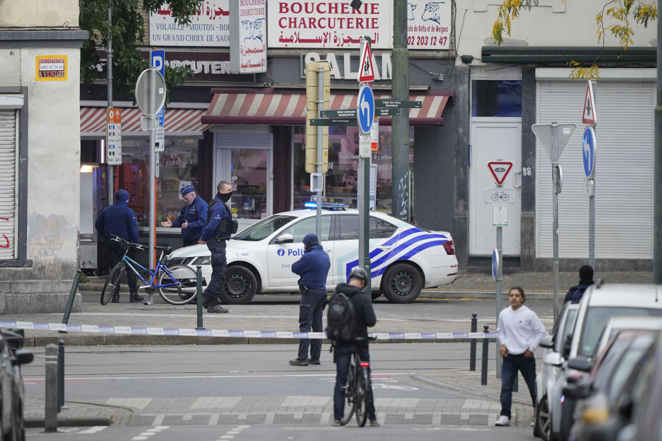 Belgian Police stand behind a cordoned off area close to where a suspected Tunisian extremist has been shot dead hours after manhunt looking for him Tuesday, Oct. 17, 2023. Police in Belgium have shot dead a suspected Tunisian extremist accused of killing two Swedish soccer fans in a brazen attack on a Brussels street before disappearing into the night on Monday. (AP Photo/Martin Meissner)