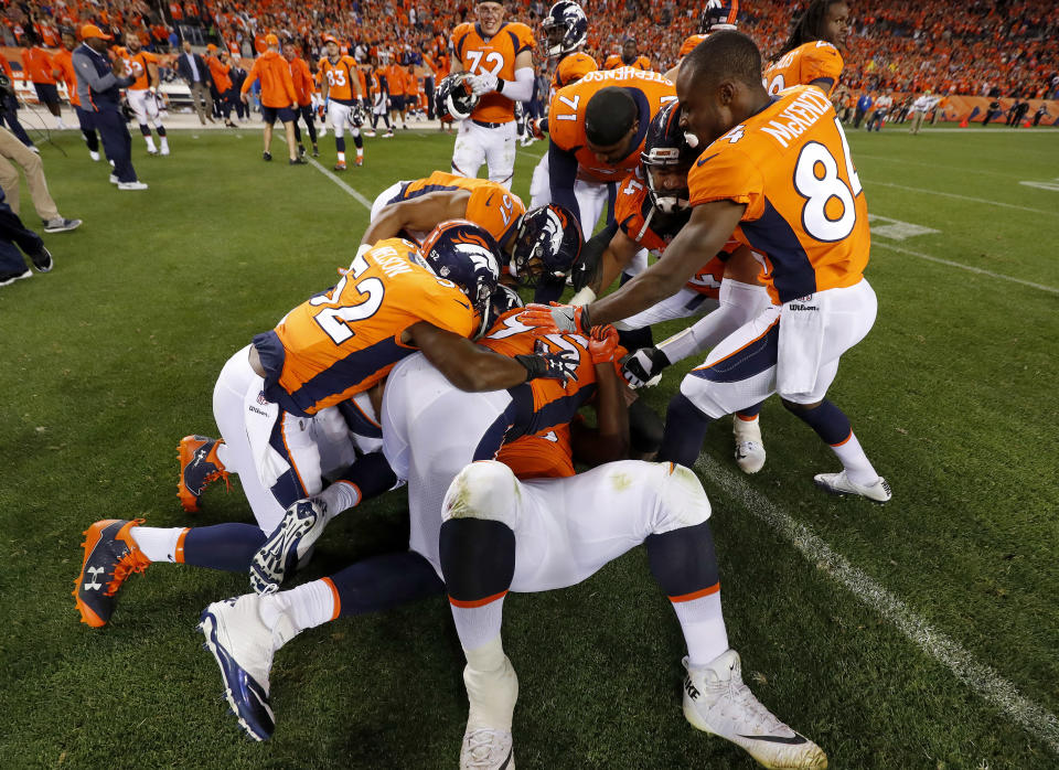 Derek Wolfe (95) hugs Shelby Harris on the bottom of a pile after Harris' game-winning field-goal block. (AP)