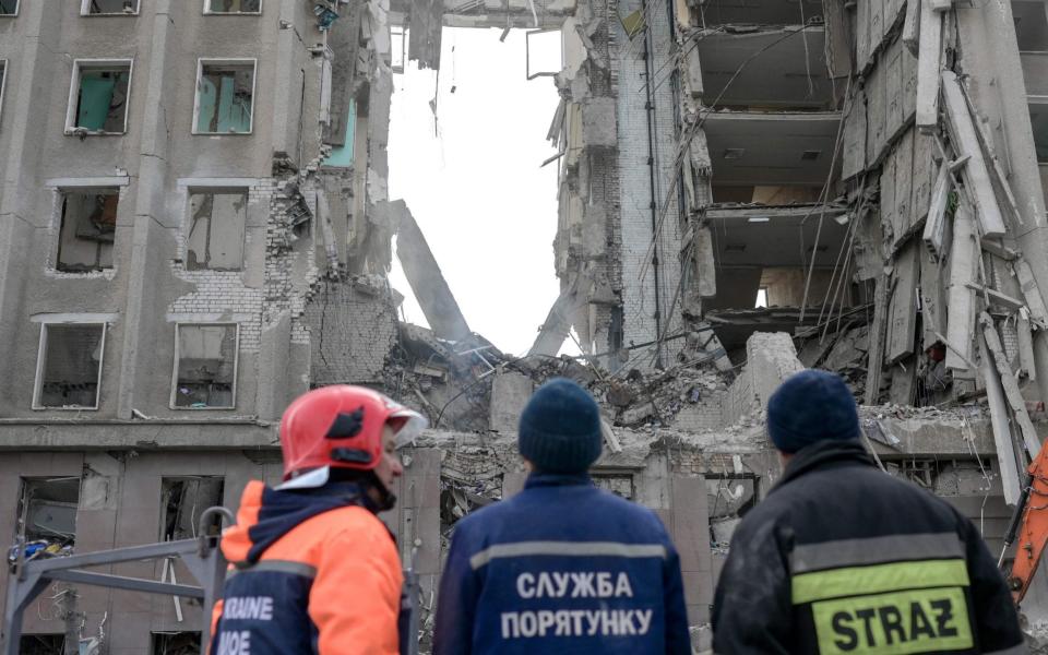 Rescue workers look at the rubble of government building hit by Russian rockets in Mykolaiv - BULENT KILIC / AFP