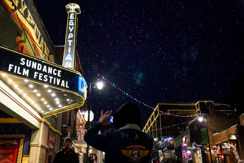 PARK CITY, UTAH - JANUARY 22: People take photos beneath the marquee of the Egyptian Theater on Wednesday, Jan. 22, 2020 in Park City, Utah. The 2020 Sundance Film Festival kicks off Thursday, Jan. 23. (Kent Nishimura / Los Angeles Times)