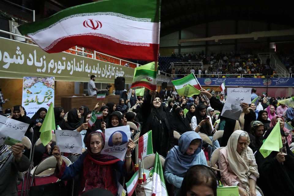 Supporters of Mohammad Bagher Qalibaf, the most prominent candidate for the June 28, presidential election, who is Iran's parliament speaker, wave the country's flags during his campaign rally in Tehran, Iran, Tuesday, June 18, 2024. (AP Photo/Vahid Salemi)