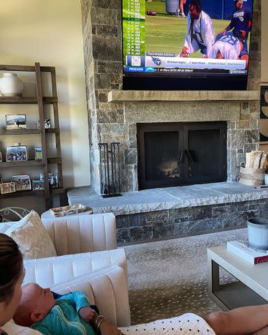 <p>Erin Andrews Instagram</p> Erin Andrews holds her son Mack Roger Stoll while watching NFL Training Camp.