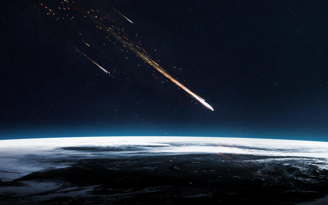 Bright white streaks showing meteors headed toward Earth's surface shown on bottom half of image.