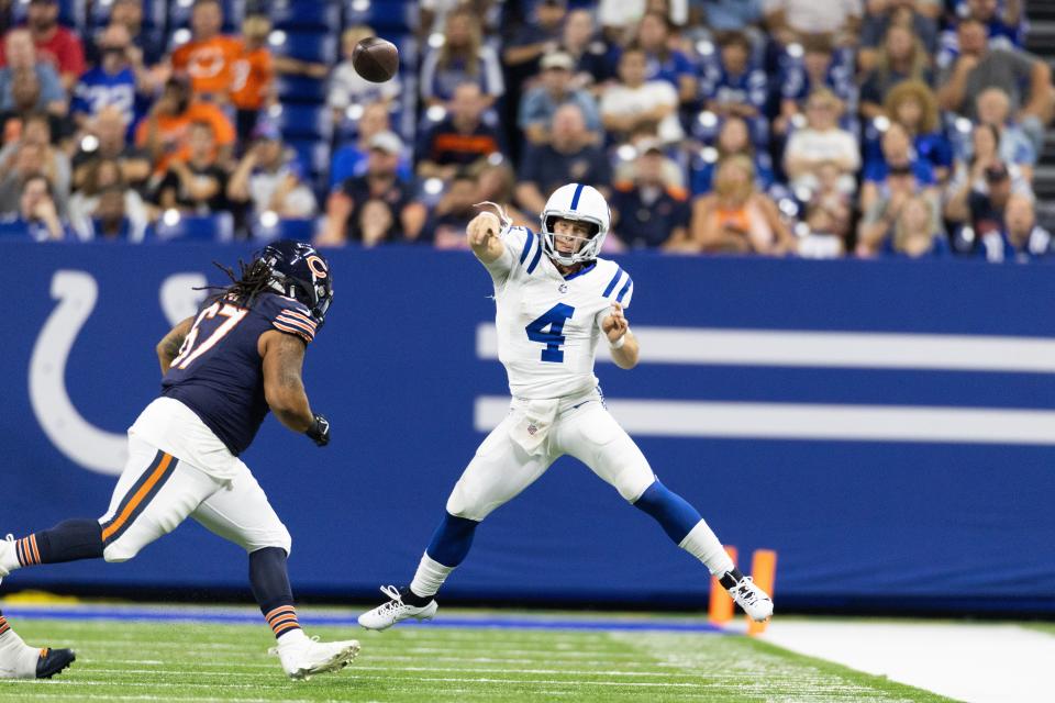 Indianapolis Colts quarterback Sam Ehlinger (4) passes the ball while Chicago Bears defensive tackle Bravvion Roy (67) defends  in the second half at Lucas Oil Stadium.