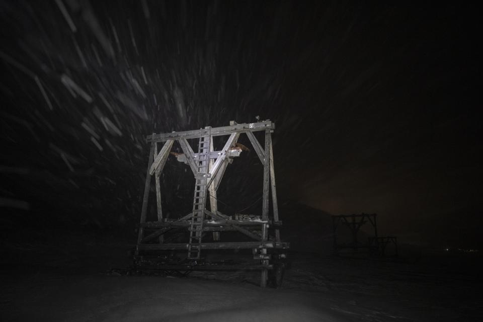 Snow falls on a disused wire rope tramway in Adventdalen, Norway, Monday, Jan. 9, 2023. For more than 100 years, people came to the remote Arctic archipelago of Svalbard to work in coal mines. (AP Photo/Daniel Cole)