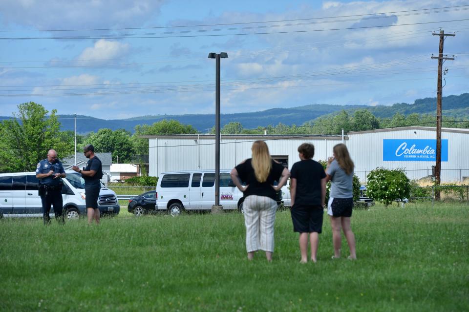 A Washington County Sheriff's Office deputy talks to bystanders following a mass shooting at Columbia Smithsburg manufacturing near Smithsburg, Md., Thursday, June 9, 2022.