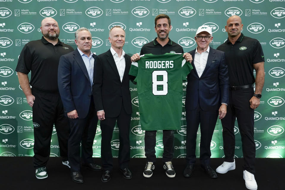 New York Jets' quarterback Aaron Rodgers, third from right, poses for a picture with general manger Joe Douglas, left, president Hymie Elhai, second from left, co-owner Christopher Johnson, third from left, owner Woody Johnson, second from right, and head coach Robert Saleh, right, after an NFL football press conference at the Jets' training facility in Florham Park, N.J., Wednesday, April 26, 2023. (AP Photo/Seth Wenig)