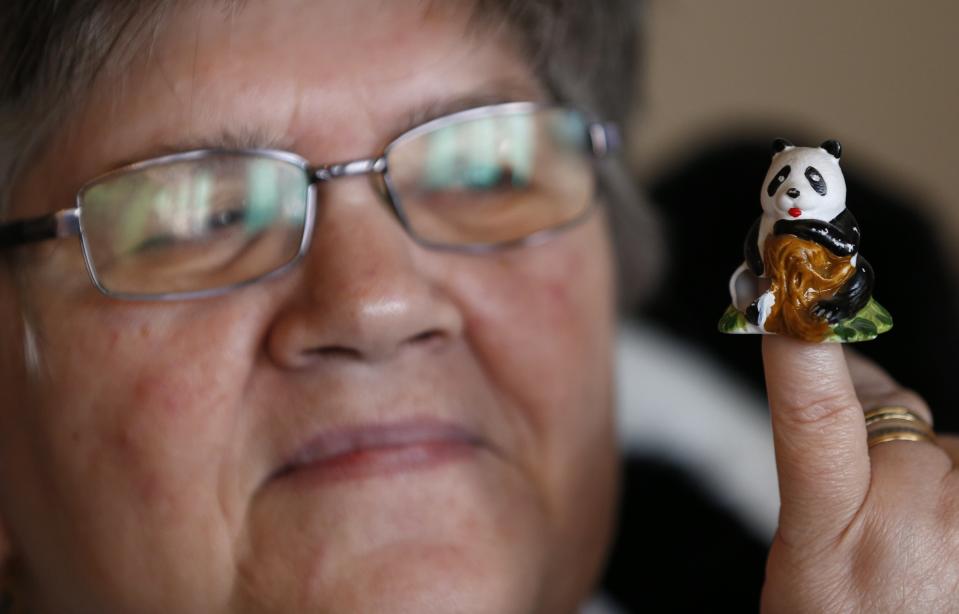 Celine Cornet holds a panda figurine, the first piece of a collection of 2,200 of panda collectables, in her house in Haccourt March 11, 2014. REUTERS/Yves Herman