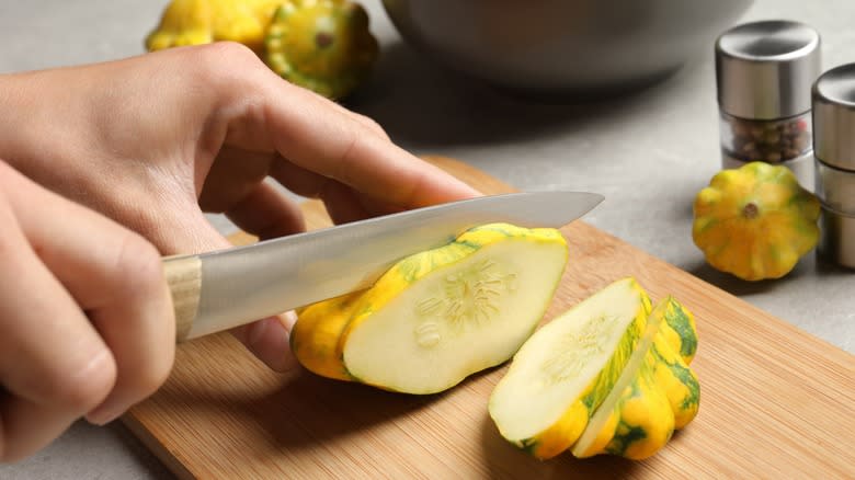 person slicing pattypan squash