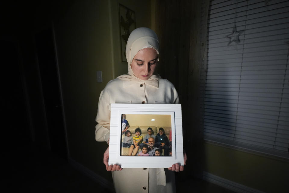 Maryam Kamalmaz muestra una fotografía de su padre con algunos de sus 14 nietos, en Grand Prairie, Texas, el 17 de enero de 2024. (AP Foto/Julio Cortez)