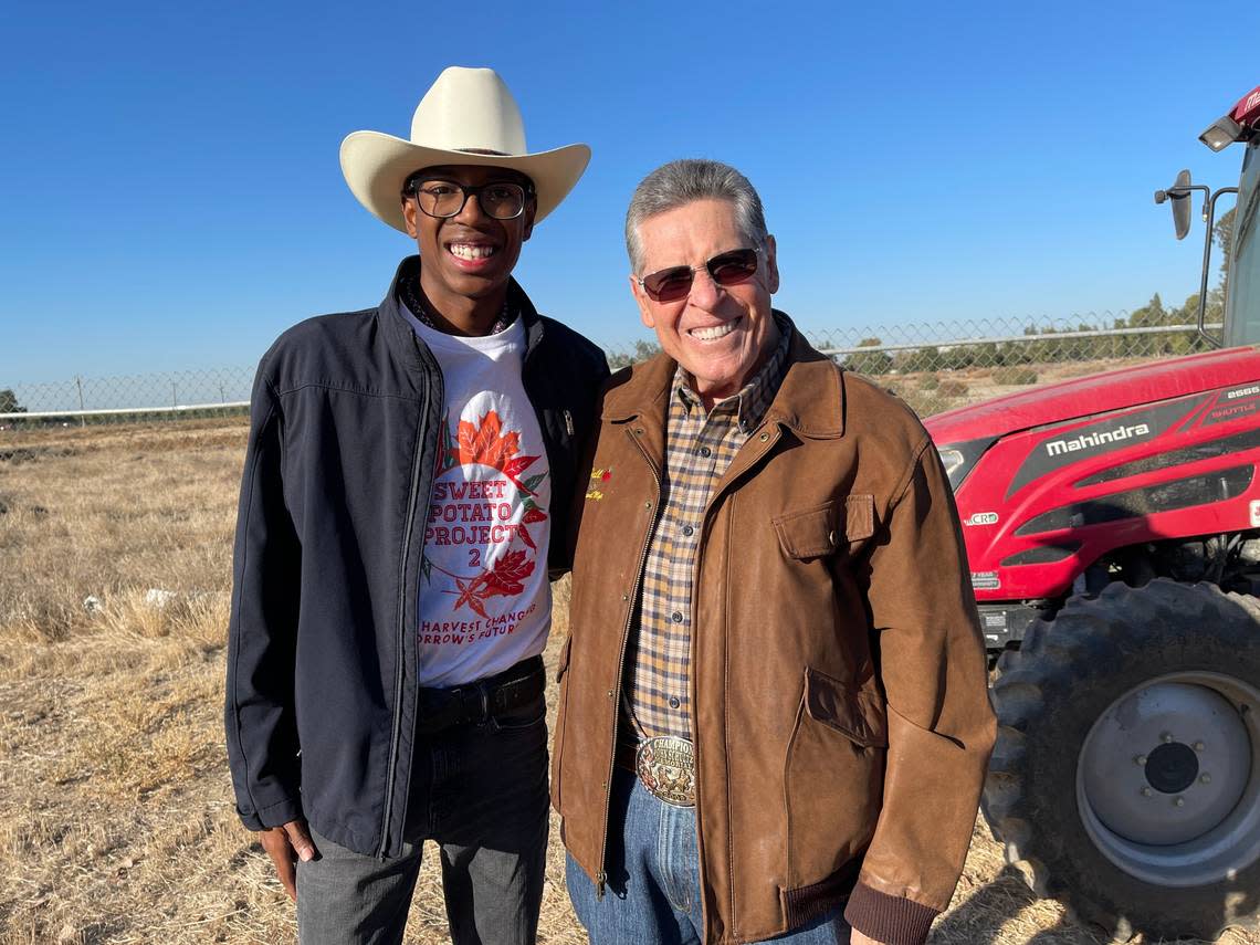 Sweet Potato Project participant, Jay-Lynn Rodriguez with Earl Hall, owner of Hall Management Corp., near a tractor donated by Hall, during the Sweet Potato harvest, Saturday, Oct. 29, 2022.