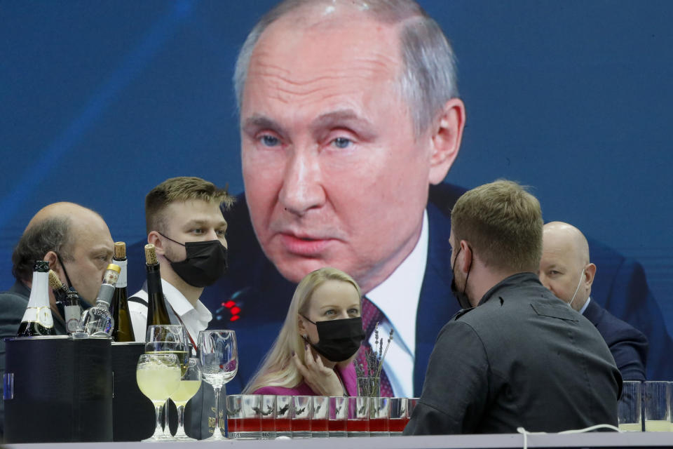 Journalists gather in the press center as they listen to Russian President Vladimir Putin speaking, at the St. Petersburg International Economic Forum in St. Petersburg, Russia, Friday, June 4, 2021. (AP Photo/Dmitri Lovetsky)
