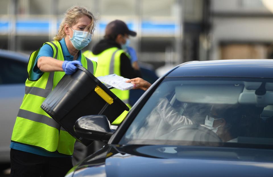 Workers collect completed Covid-19 tests at a drive-in testing centre in Bolton (AFP via Getty Images)