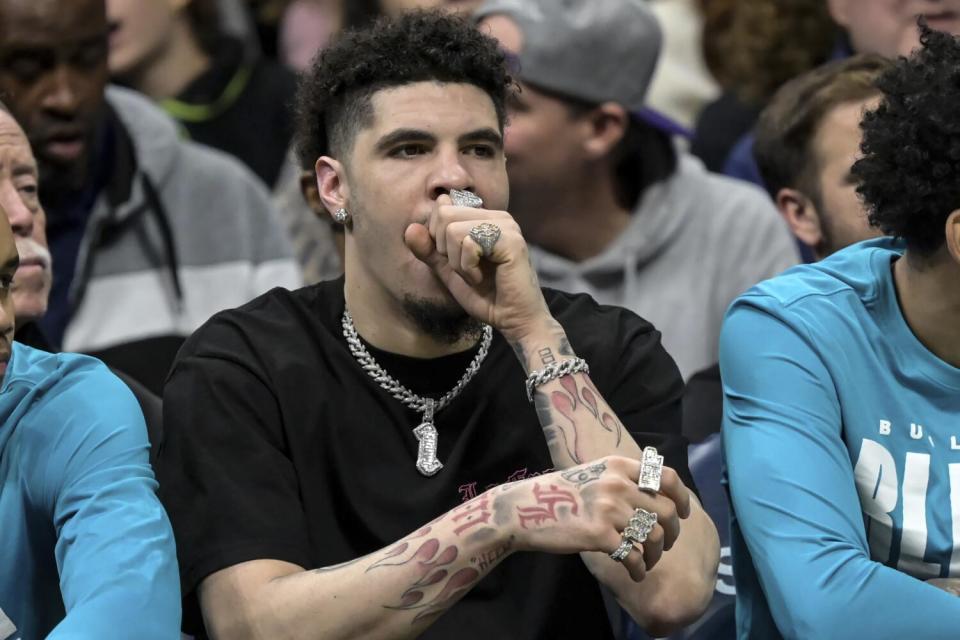 Hornets' LaMelo Ball appears to yawn as he looks on from the bench