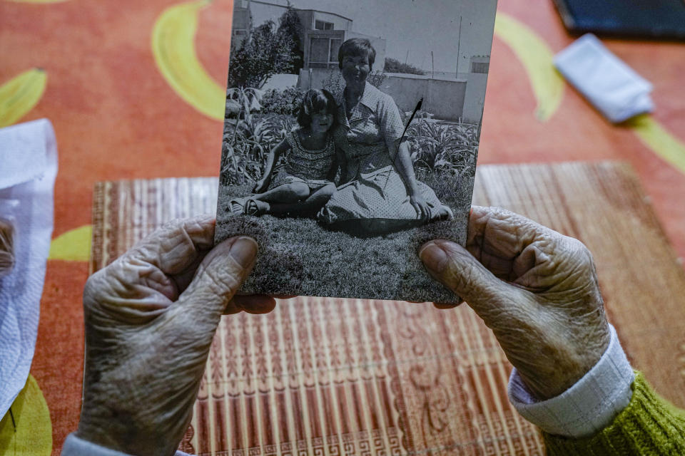 Eliana Rodríguez sostiene una fotografía de ella con su hija Yelena Monroy en su casa en La Serena, Chile, el viernes 1 de septiembre de 2023. La fotografía fue tomada un año después de que fueron liberadas de un centro de detención donde estuvieron Rodríguez y sus dos hijas pequeñas encarceladas por más de un año durante la dictadura del general Augusto Pinochet, quien llegó al poder después de un golpe militar en septiembre de 1973. (AP Foto/Esteban Felix)