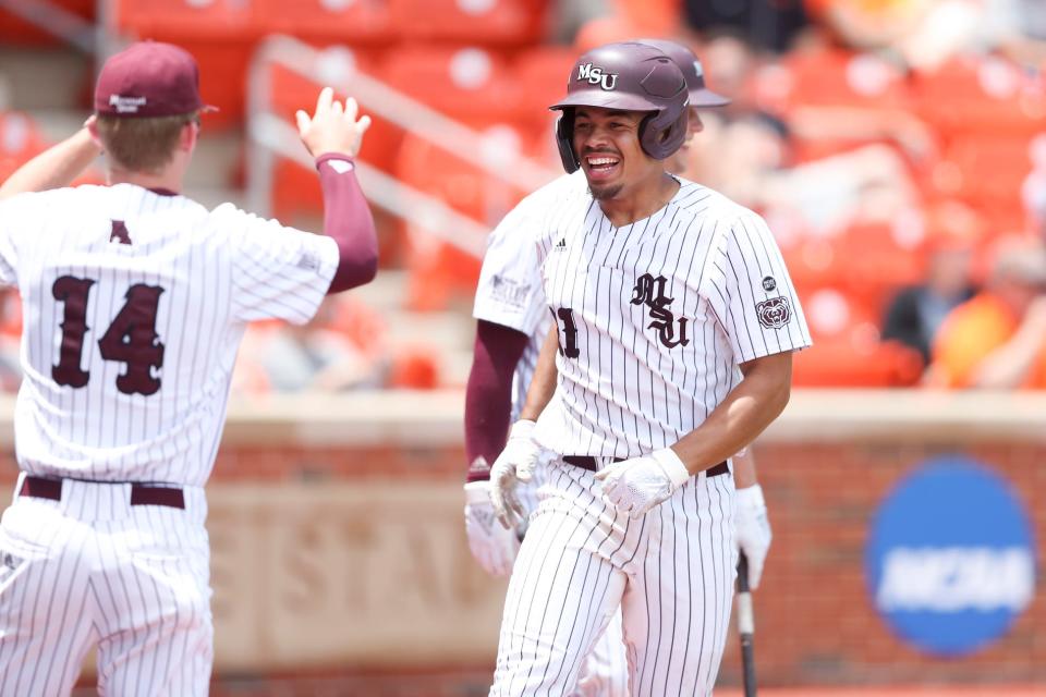 Missouri State's Drake Baldwin, right, smiles while celebrating with Hayden Moore (14) after hitting a home run  against Oklahoma State during an NCAA college baseball tournament regional game Sunday, June 5, 2022, in Stillwater, Okla. (Ian Maule/Tulsa World via AP)
