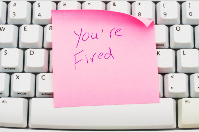 A pink sticky note sitting on a computer keyboard, You are fired