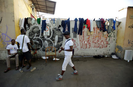 A migrant walks through a makeshift camp in Via Cupa (Gloomy Street) in downtown Rome, Italy, August 1, 2016. REUTERS/Max Rossi