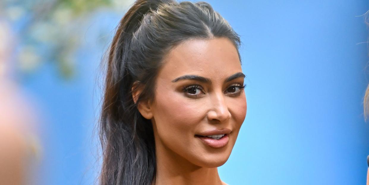 kim kardashian smiles with a ponytail in sports wear