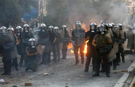 Riot police stand guard outside a police station during clashes between police and angry anti-fascist protesters following the killing of anti-racism rapper Pavlos "Killah P" Fissas, 35, by a man who sympathized with the far-right Golden Dawn group, in an Athens suburb September 18, 2013. REUTERS/Yannis Behrakis