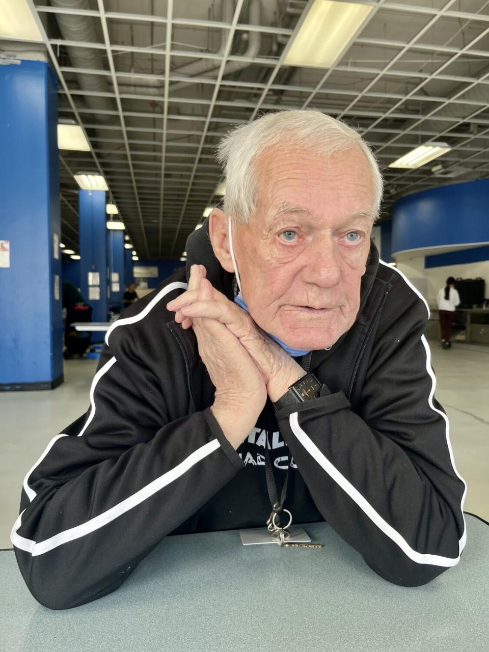 Michael Kelly, 76, sits at a table.