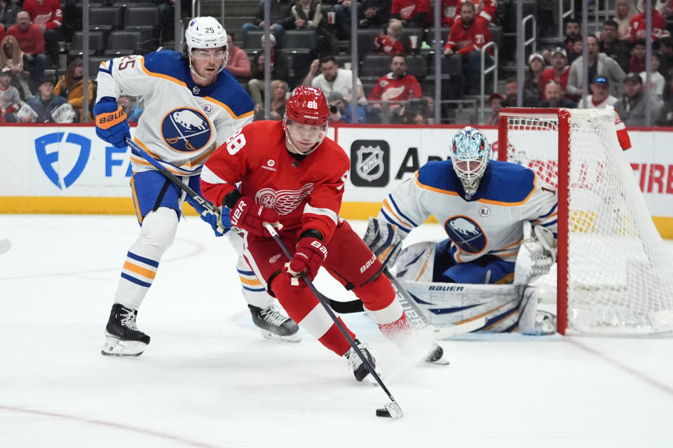 Detroit Red Wings right wing Patrick Kane (88) skates with the puck as Buffalo Sabres' Owen Power (25) defends with goaltender Ukko-Pekka Luukkonen (1) in the second period of an NHL hockey game Sunday, April 7, 2024, in Detroit. (AP Photo/Paul Sancya)