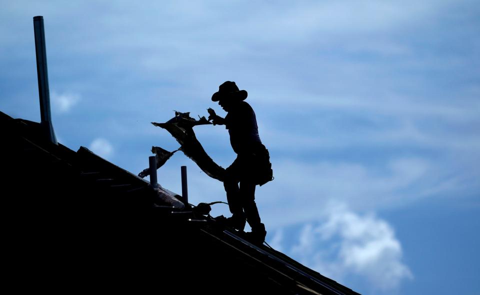 A roofer works on a new home under construction Thursday, July 18, 2019, in Houston. A heat wave is expected to send temperatures soaring close to 100 degrees through the weekend across much of the country. The National Weather Service estimates that more than 100 heat records will fall on Saturday. Most will not be the scorching daily highs, but for lack of cooling at night, something called nighttime lows. Those lows will be record highs. 