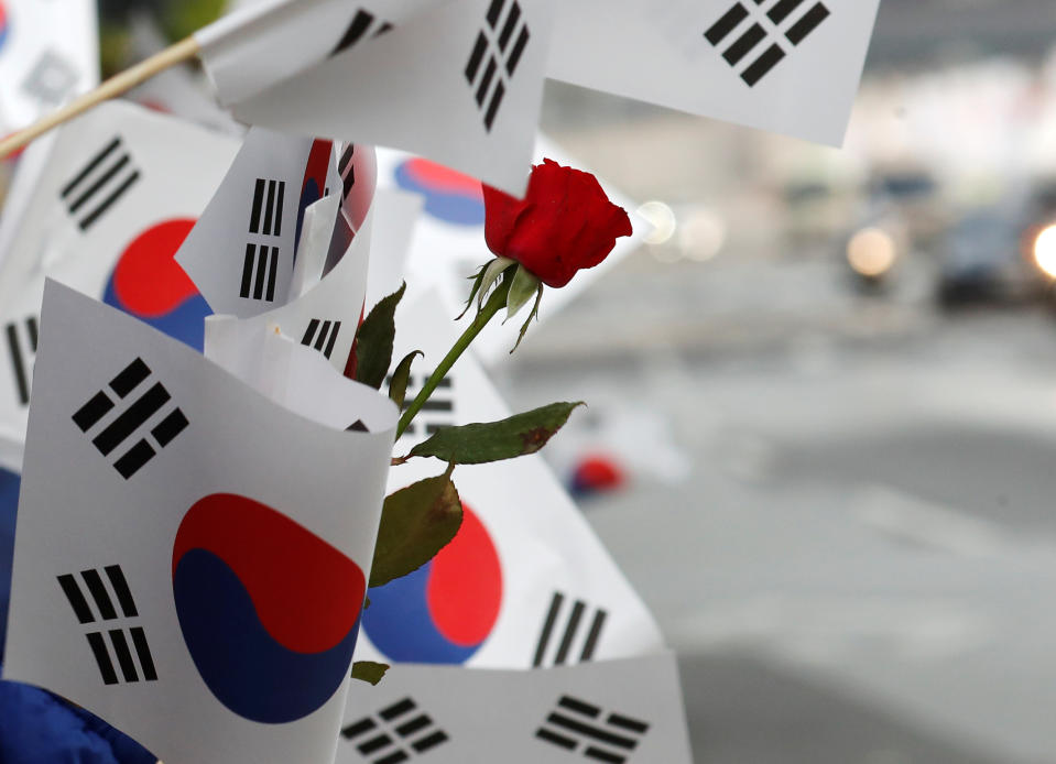<p>South Korean flags and a flower is seen waved by people as a convoy transporting South Korean President Moon Jae-in leaves the Presidential Blue House for the inter-Korean summit in Seoul, South Korea, April 27, 2018. (Photo: Jorge Silva/Reuters) </p>