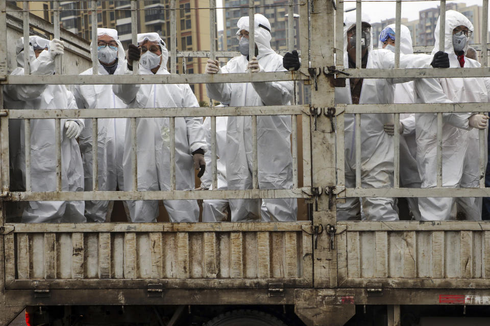 In this Thursday, Feb. 6, 2020, photo, workers in protective suits ride on a truck carrying medical supplies into Huoshenshan temporary hospital built for patients who diagnosed with 2019-nCoV in Wuhan in central China's Hubei province. The number of confirmed cases of the new virus has risen again in China on Saturday as the ruling Communist Party faced anger and recriminations from the public over the death of a doctor who was threatened by police after trying to sound the alarm about the disease over a month ago. (Chinatopix via AP)