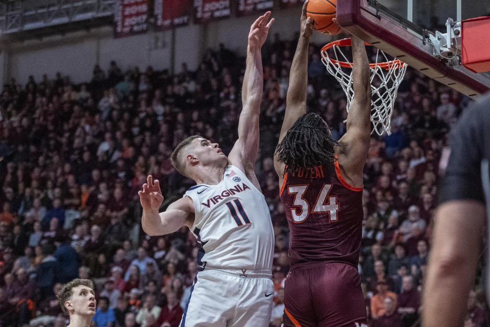 Virginia Tech's Mylyjael Poteat dunks over Virginia's Isaac McKneely during the first half of an NCAA college basketball game, Monday, Feb. 19, 2024, in Blacksburg, Va. (AP Photo/Robert Simmons)