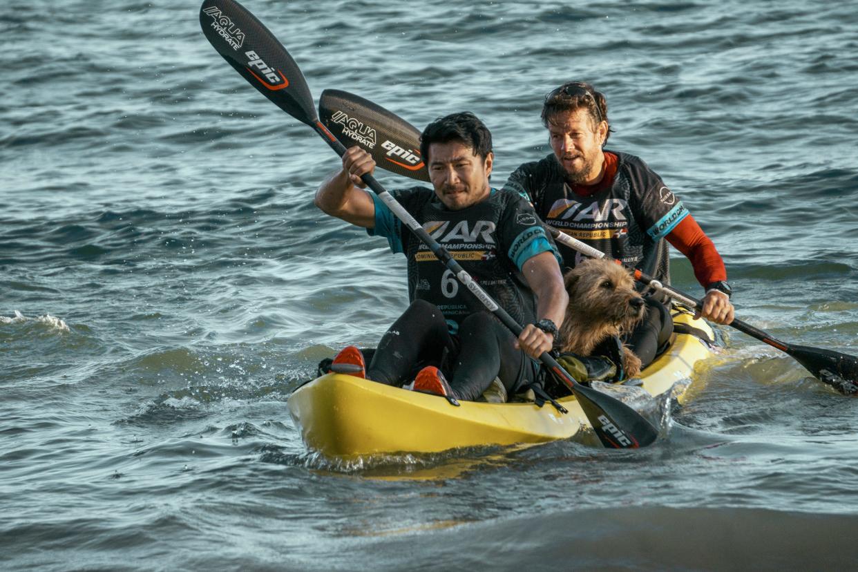 Simu Liu as Leo and Mark Wahlberg as Michael in "Arthur The King." The duo decide to take Arthur in the kayak section of the race.