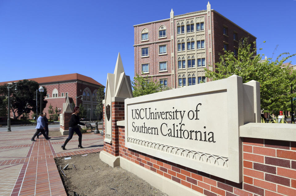 FILE - People walk by a sign at the University Village area of the University of Southern California in Los Angeles on March 12, 2019. In the wake of a Supreme Court decision that removes race from the admissions process, colleges are coming under renewed pressure to put an end to legacy preferences, the practice of favoring applicants with family ties to alumni. (AP Photo/Reed Saxon, File)