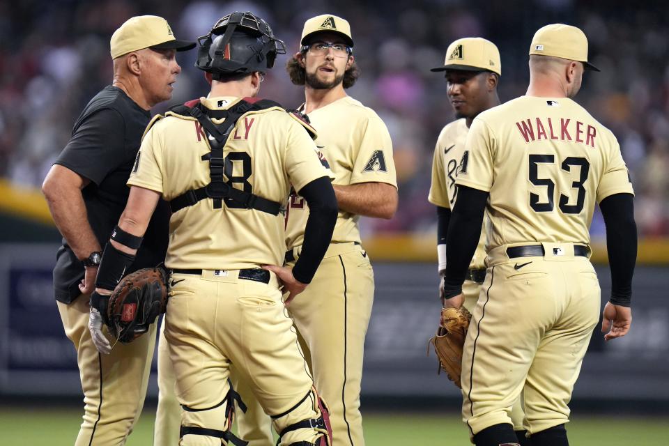 Sep 17, 2022; Phoenix, Arizona, USA; Arizona Diamondbacks pitcher Zac Gallen , center, looks off as pitching coach Brent Strom approaches the mound during their game against the San Diego Padres at Chase Field. Mandatory Credit: Joe Rondone-Arizona Republic