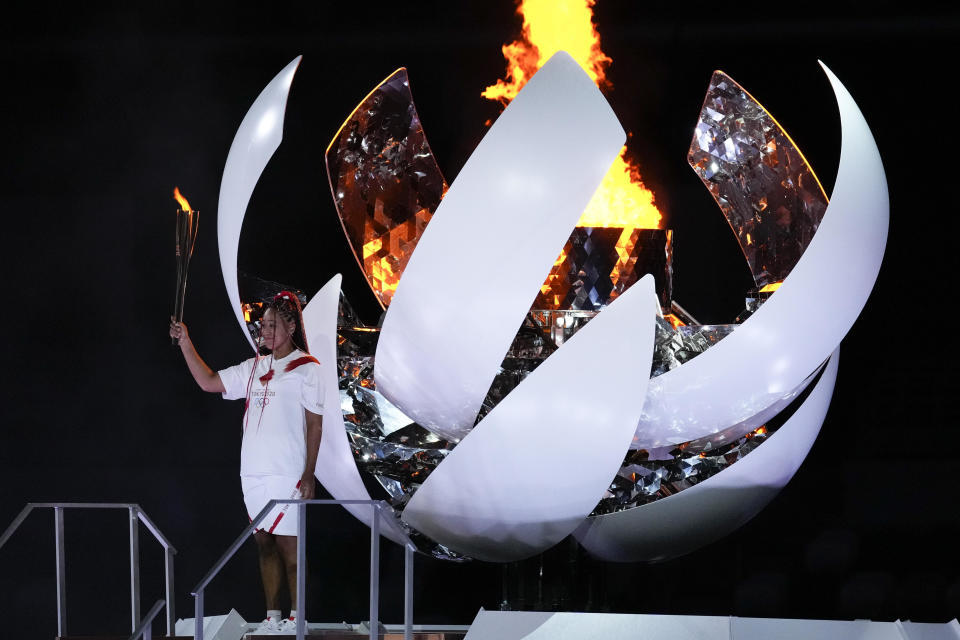 Japan's Naomi Osaka reacts after lighting the cauldron during the opening ceremony in the Olympic Stadium at the 2020 Summer Olympics, Friday, July 23, 2021, in Tokyo, Japan. / Credit: Ashley Landis / AP