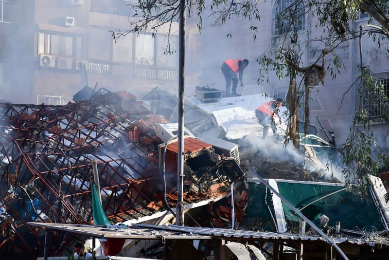 Emergency and security personnel inspect the rubble at the site of strikes that hit a building annexed to the Iranian embassy in Syria's capital Damascus on Monday. The strike, itself, took place on a building between the Iranian and Canadian embassies in the Syrian capital. Photo by Syrian Arab News Agency/UPI