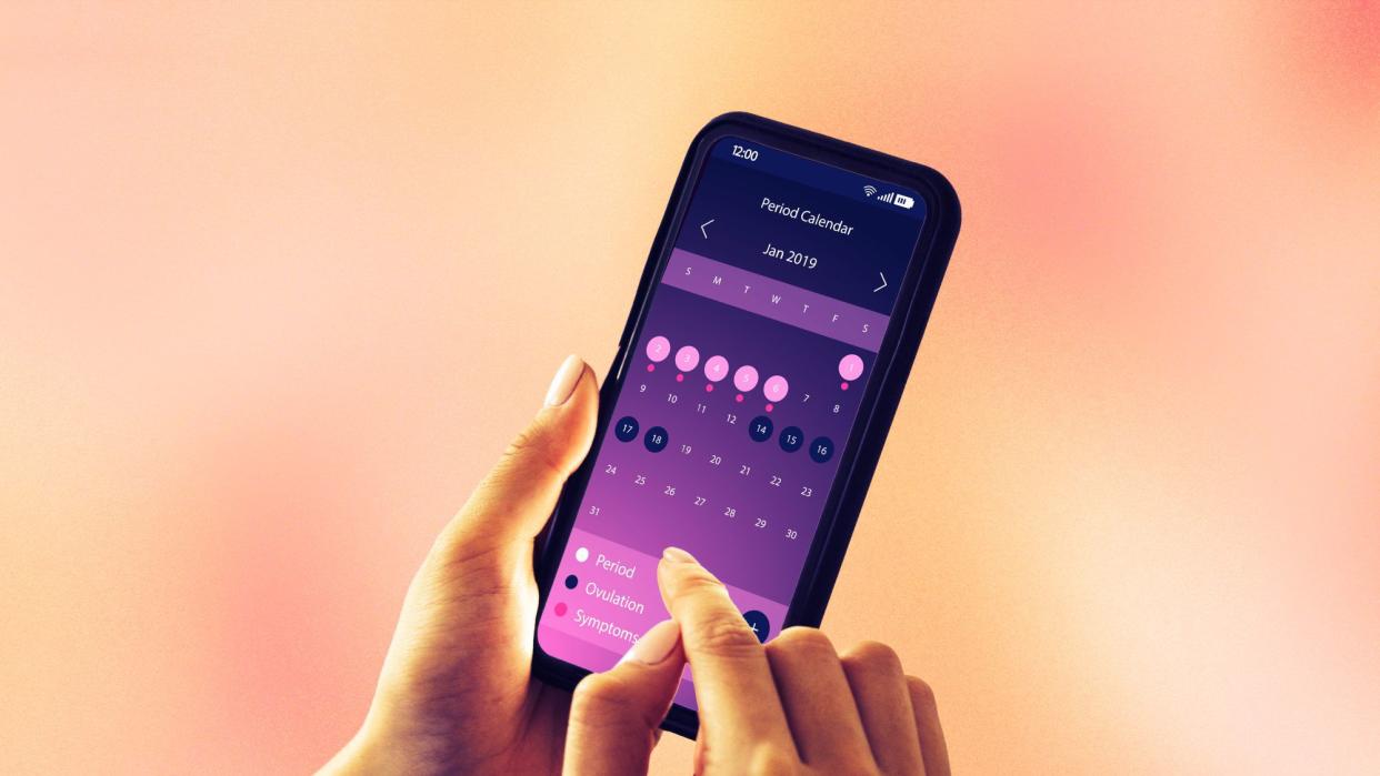 hands holding phone with period tracking app on screen