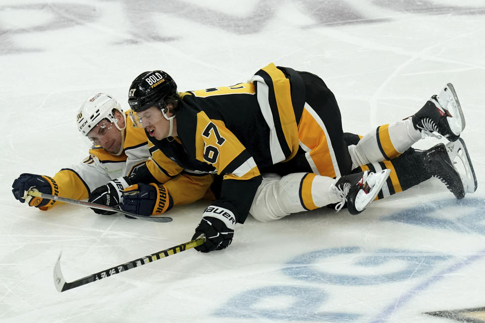 Pittsburgh Penguins' Rickard Rakell (67) lands on top of Nashville Predators' Cole Smith, left, during the third period of an NHL hockey game, Monday, April 15, 2024, in Pittsburgh. (AP Photo/Matt Freed)