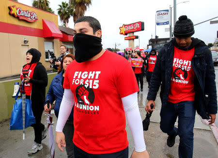 Local fast food workers take part in nationwide protests to denounce President-elect Donald Trump's nomination of Andy Puzder, a restaurant mogul who owns Carl's Jr. and other chains, as U.S. Secretary of Labor outside a Carl's Jr. restaurant in Los Angeles, California, U.S., January 12, 2017. REUTERS/Mike Blake