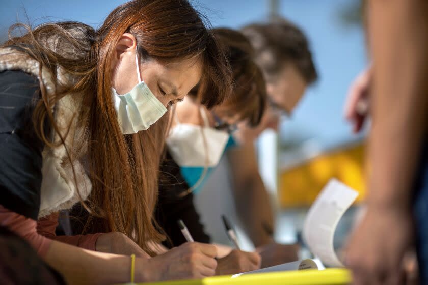 People sign petitions as conservative activists gather signatures in a recall effort against California Governor Gavin Newsom near Pasadena City Hall, in Pasadena, California on February 28, 2021. (Photo by DAVID MCNEW / AFP) (Photo by DAVID MCNEW/AFP via Getty Images)