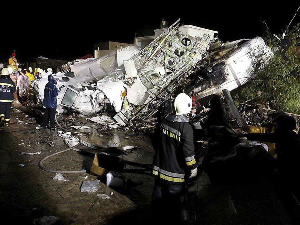 Rescue personnel survey the wreckage of TransAsia Airways flight GE222 on Taiwan's offshore island of Penghu, July 23, 2014. A TransAsia Airways turboprop ATR-72 plane crashed on its second attempt at landing during a thunderstorm on Penghu, an island off Taiwan on Wednesday, killing 47 people and setting buildings on fire, officials said. REUTERS/Wong Yao-wen (TAIWAN - Tags: ENVIRONMENT TRANSPORT DISASTER TPX IMAGES OF THE DAY)